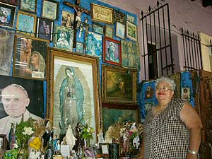 The owner of Las Palmeras Restaurant proudly displaying her shrine