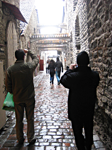 A couple hurries down St. Catherine's Passage, one of the most picturesque place in Tallinn