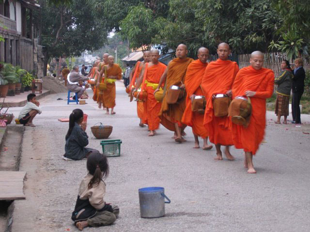 Children give offerings of food to the monks in Luang Prabang.