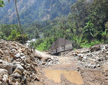 A collapsed house on the road around the lake