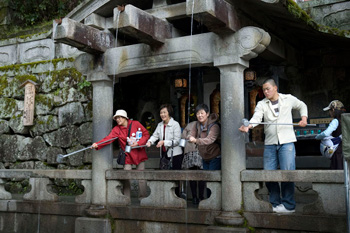 Visitors catch holy water at Kiyomizudera Temple, Kyoto, Japan