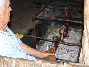 A shepherd turns piglets on a spit in Sardinia.