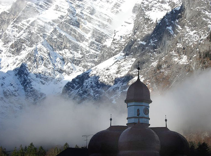 The onion-top roofs of Saint Bartholomew at Lake Königsseein Bavarian Alps, Germany. Photo by Sony Stark.