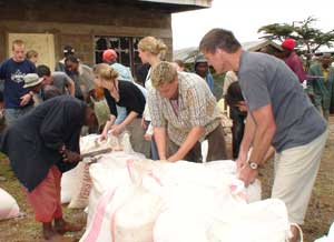 Mark helps distribute food to waiting villagers.