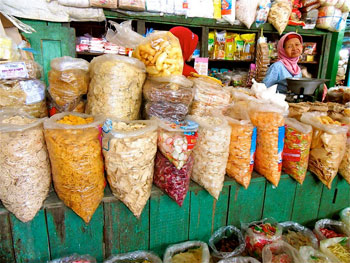 A market vendor selling everything from rice crackers to sachets of pre-made Jamu