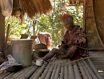 Making bamboo strips to bind a knife blade to a handle. Pan Au village