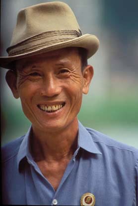 A Taste of Hanoi's Braised Fish Street 6 A happy citizen with Ho Chi Minh badge, by Lake Hoan Kiem.
