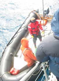 A traveler works his way down the gangway and onto the Zodiac boat below.