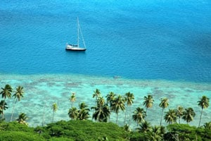 A sailboat glides through the azure waters