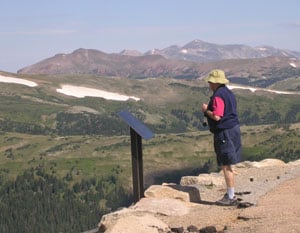 A tourist gazes at the view atop Rocky Mountain National Park.