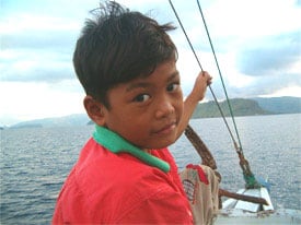 Eko, our boat captain’s son, plays in the wind on board a “klotok” during our two-day trip.
