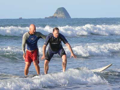 Greg Page of Hang 20 Surfing, helps Max get up on the board. 
