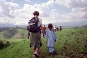 Africa: Cameroon by Bicycle 3 A volunteer walks with a child in Cameroon.