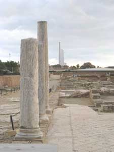 Ancient Roman pillars and a modern electrical plant in the distance 
