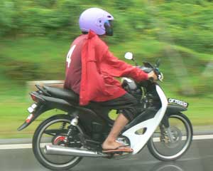 A motorcyclist braves the rain in Kuching