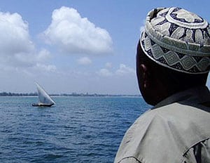 Man watching a dhow from the ferry from Dar es Salaam to Zanzibar
