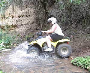 Caving and Quad Biking in Oudtshoorn, South Africa 7 An adventurer rides her quad bike through a stream near the Swartberg Mountains. Photo by Carly Blatt