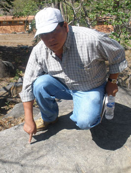 Our guide points out an ancient petroglyph in Tehuacalco, Mexico.