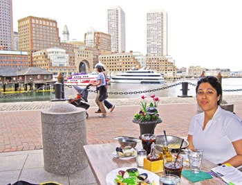 Esha at The Daily Catch with the Boston skyline in the background.
