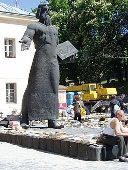 An outdoor bookmarket in Lviv, Ukraine beneath a monument to Ivan Fedorov, the city's first printer