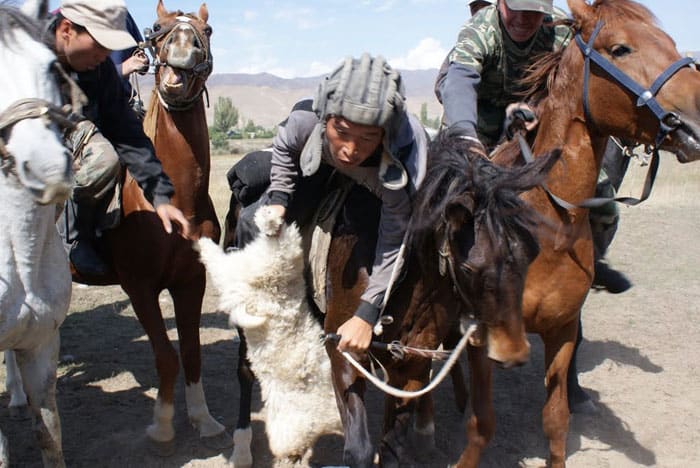 A rider reaches forward in a bid to score.