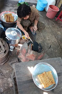 A vendor at the Kampot market makes coconut waffles on a griddle greased with coconut oil.