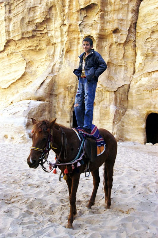 A boy shows off his riding skill in Little Petra, Jordan.
