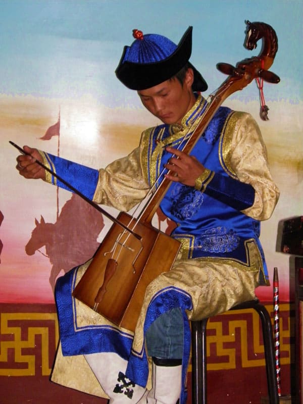 Playing a two-stringed horsehair fiddle in Shangtu, Mongolia