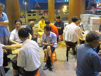 Men gather to play Mahjong on a warm summer evening in Enshi.