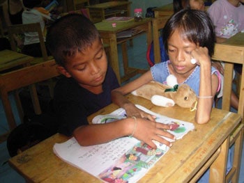 Pim helping one of the younger children to read