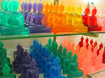 One Day in Bangkok for Less Than Ten Dollars (US) 10 Multi-colored glass Buddhas adorn a shelf at Chatuchak Market.