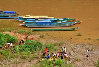 Locals sell food by the riverside.