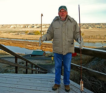 Wahkpa Chu’gn is the most extensive and best preserved Native American hunting ground and buffalo bone deposit in the northern Great Plains. In this photo, John Park is holding the atlatl, an ancient weapon. 