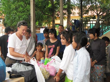 Lori Carlson hands out donations at a Siem Reap children's shelter. Photo by Shelley Seale