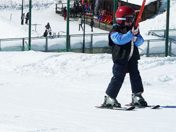 Kid skiier on the poma lift.