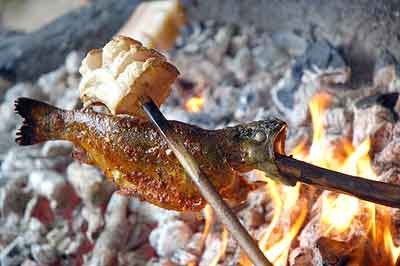 Local trout cooked by melting fat on the fish over a fire.