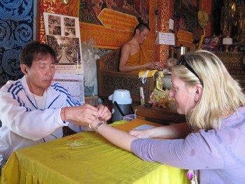 Receiving my blessing at Doi Suthep Temple from the Monks' helper as the Monk is not allowed to touch or to be touched by a woman.