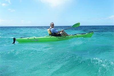 Kayaking in the blue waves off the coast of Molokai Hawaii. photo: Molokai Outdoors.