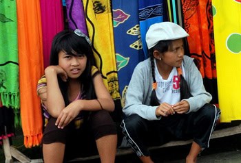 Girls selling sarongs in front of a temple