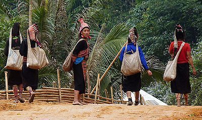 Akha hill tribes women with traditional headgear heading out of the village. Photos by Holly Cave.