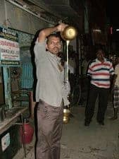 A vendor prepares warm milk for sale in India.