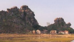 A typical scene outside Van Long Nature Preserve, not far from Cuc Phuong. The landscape is dominated by the huge, weirdly shaped, eroded limestone hills. Like many homes in the area, the house in the foreground has a fish pond in its front yard. Photo by Dan Drollette