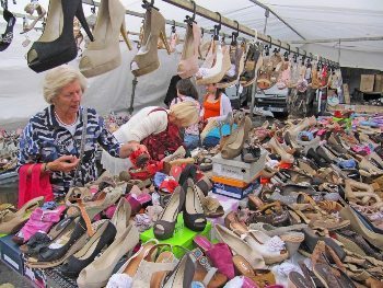 Women and many shoes at the market.