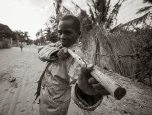 A local boy imitates the rebels and other forces that play important roles in Mozambique.