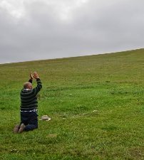 A family elder pays respects to the Mountain Spirit before departing from the annual gathering.