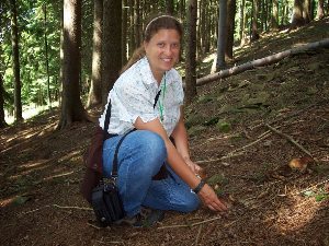 Nelinda brasher picking mushrooms in the woods.