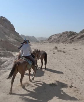 Riding through a dry riverbed.