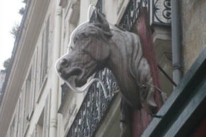 France: They Eat Horses, Don't They? A horsehead sticking out from a building, denoting a horsemeat shop.