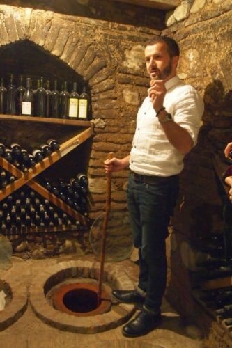 A winemaker shows off some of his qvevri underground casks where wine is aged. - Copy