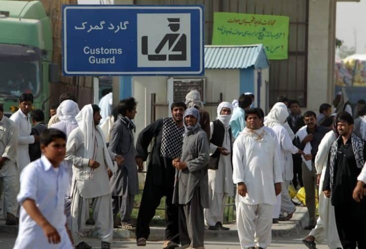Men in the street with their white pants and hats unlike those worn in other parts of Iran.